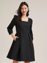 a lady in black jacquard mini dress with long sleeves